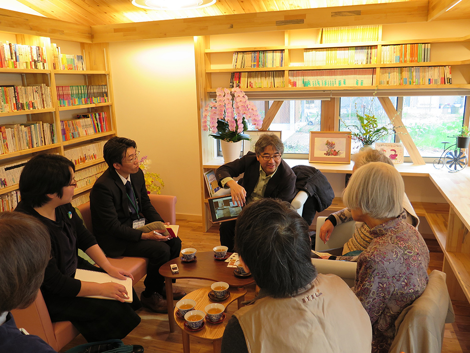 まちライブラリー提唱者・礒井純充さんをお招きして話を聞く入居者。まちライブラリーとは、カフェ、個人宅、病院、お寺など、さまざまな場所にある本棚に人が集い、メッセージつきの本を通じて自分を表現し人と交流する、みんなでつくる図書館のこと。